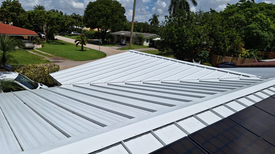 Clean white metal roof soft washed in South Florida with solar panels